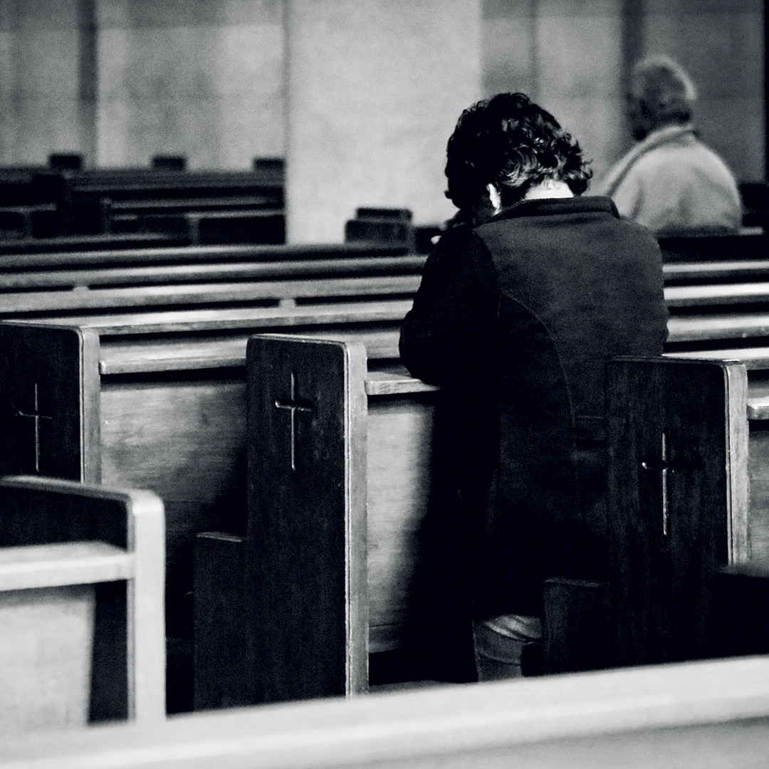 Człowiek modlący się w kościelnej ławce
