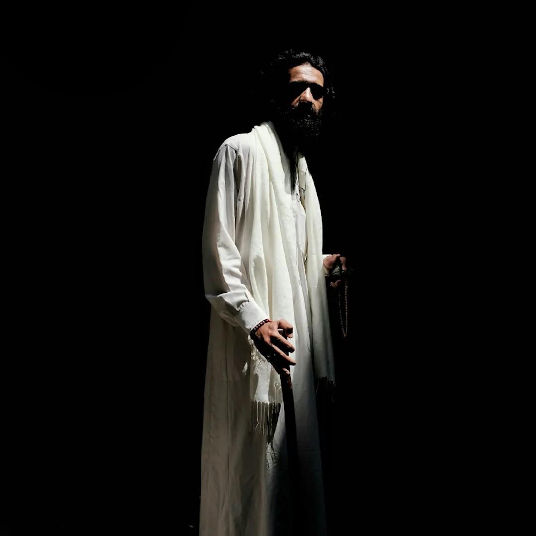 Człowiek w białej szacie w półcieniu