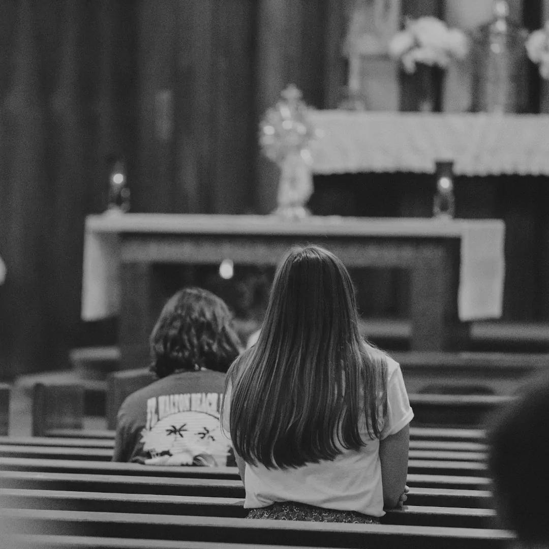 Ludzie w kościele adorujący Najświętszy Sakrament